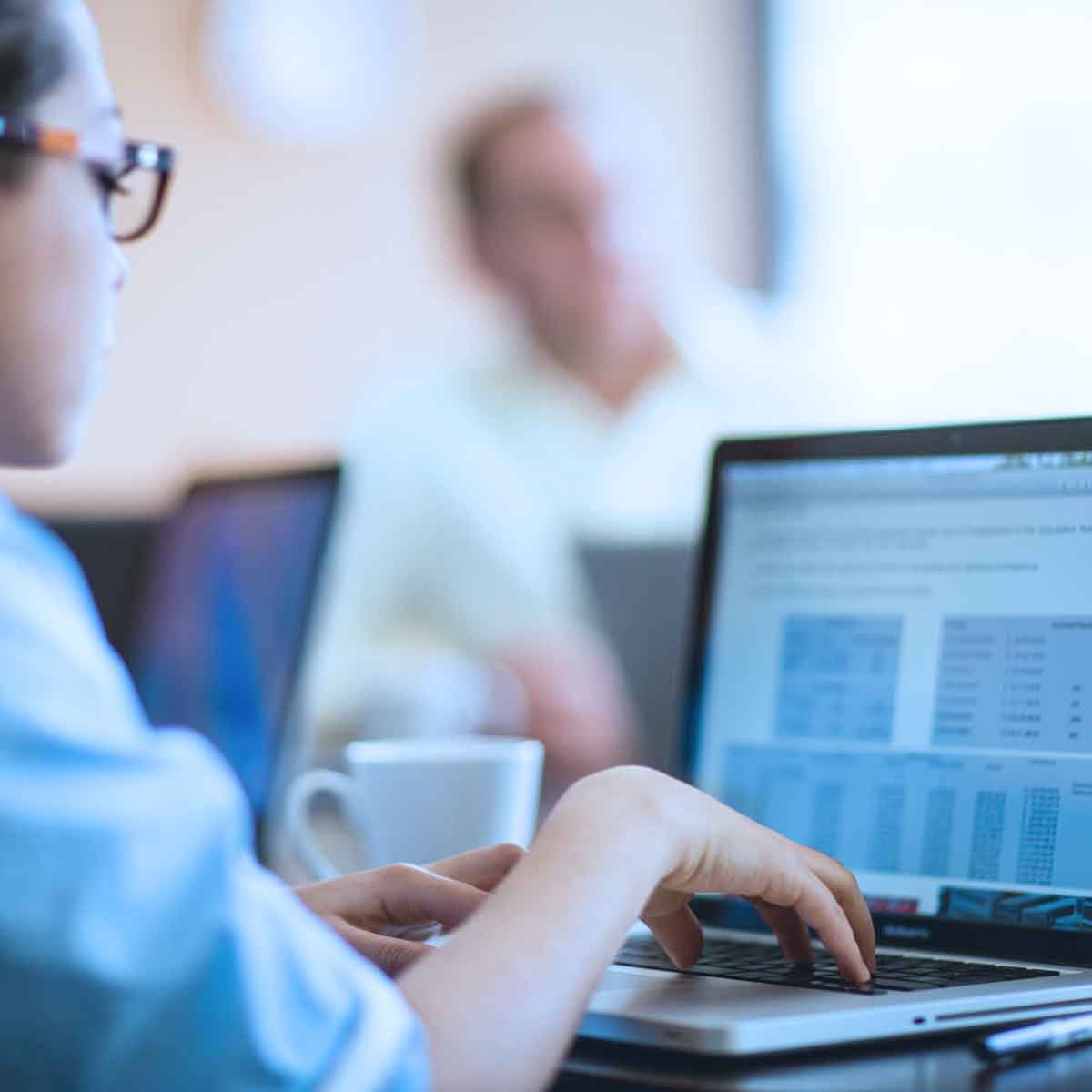 Compliance analyst working on laptop